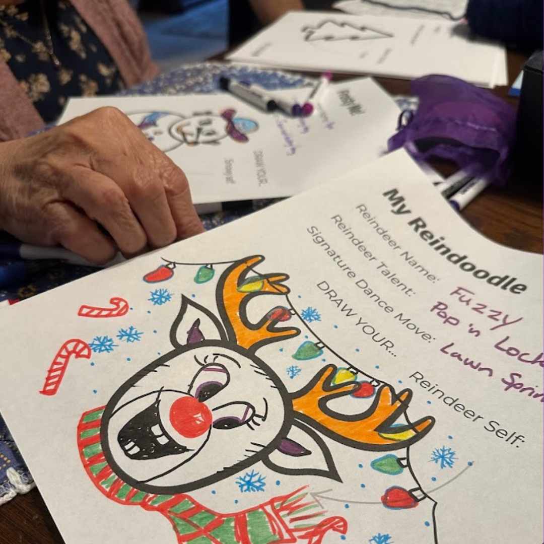 A festive reindeer coloring page titled My Reindoodle being filled in by grandma, featuring bright antlers, holiday lights, and prompts like Reindeer Name and Signature Dance Move. A joyful creative activity for all ages.